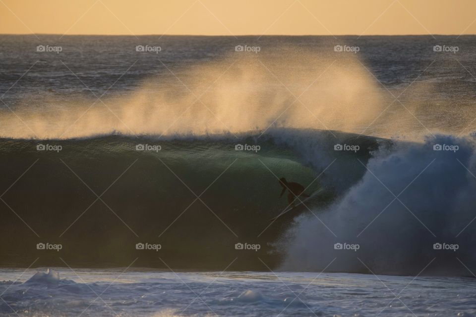 Surfer getting tubed at the Backdoor portion of banzai pipeline 