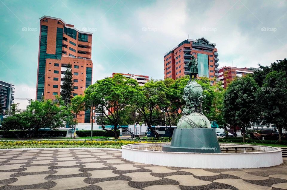 Monument to Christopher Columbus in Guatemala City, with a beautiful view of the buildings and trees that adorn it