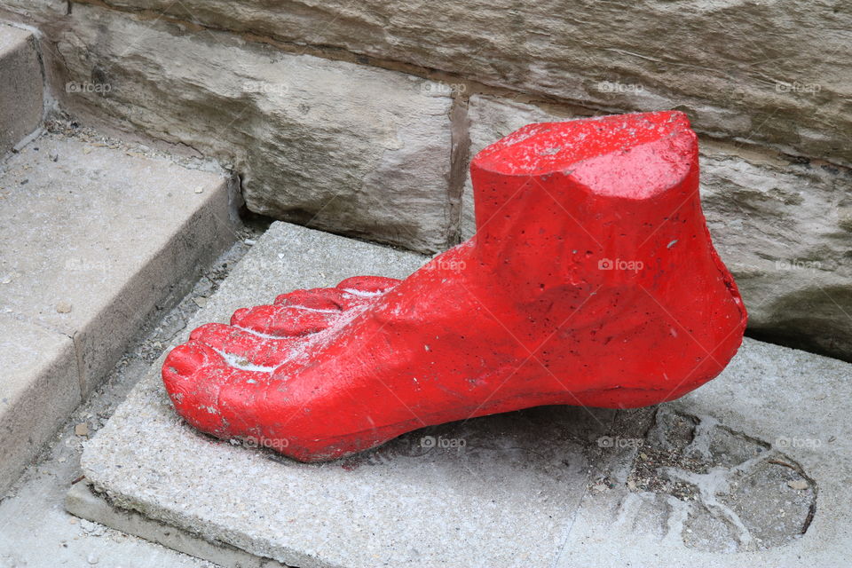 a red foot art piece on the streets of chicago