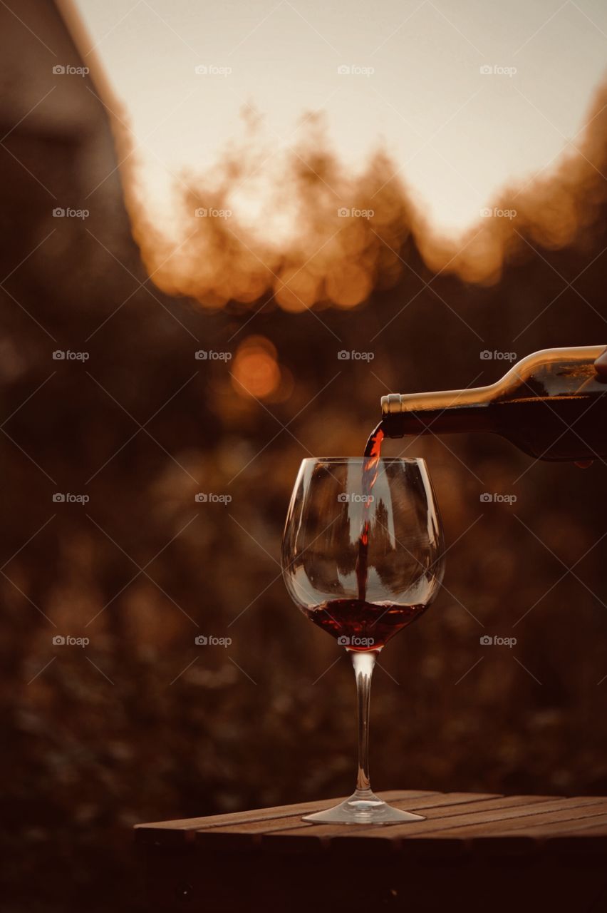 a glass of red wine at sunset in the autumn in the village