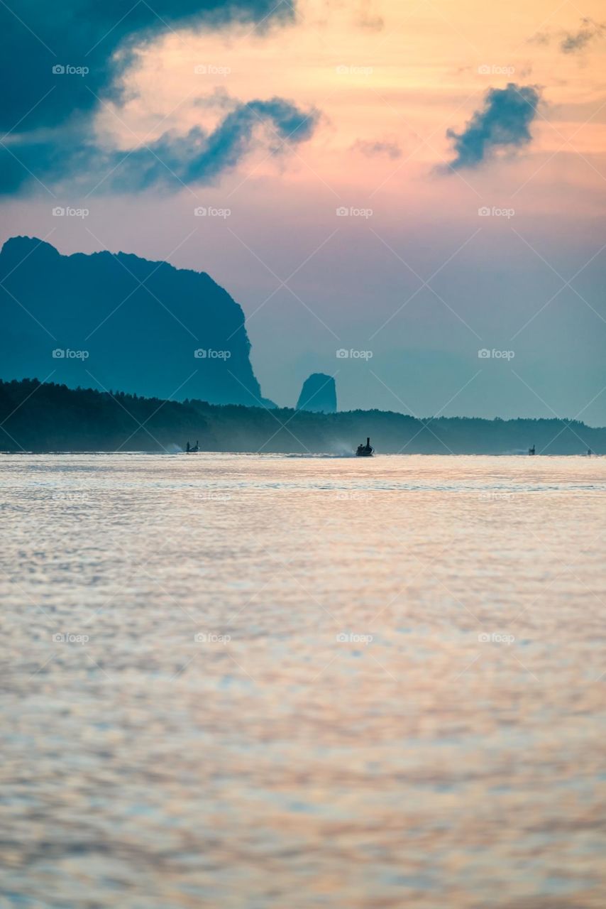 Beautiful Sunrise moment above silhouette of boat in sea