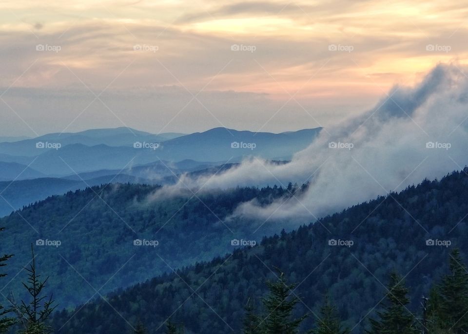 Clouds being blown down a mountainside in the Great Smoky Mountains National Park. Sunset colors from the Clingmans Dome parking lot.