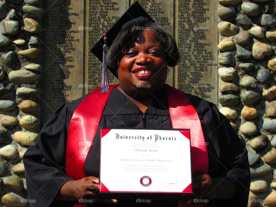 graduate holding up diploma