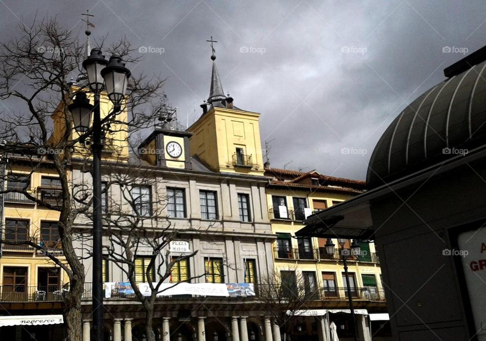 Grey and yellow buildings in a plaza.
Grey and Illuminating.