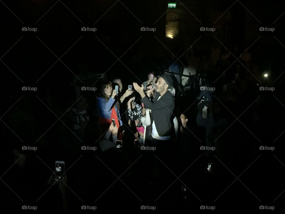 Audience taking selfie of male singer singing