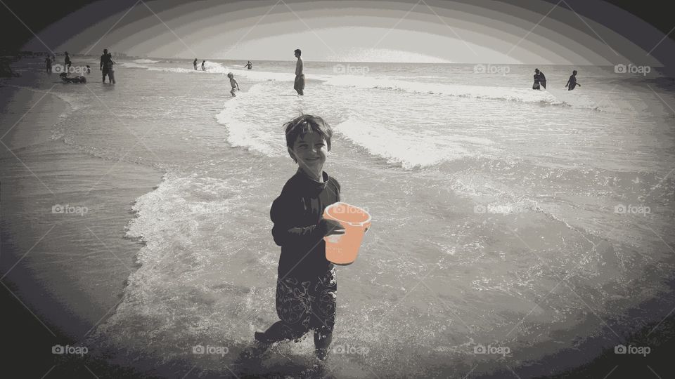 orange bucket. boy playing at the beach