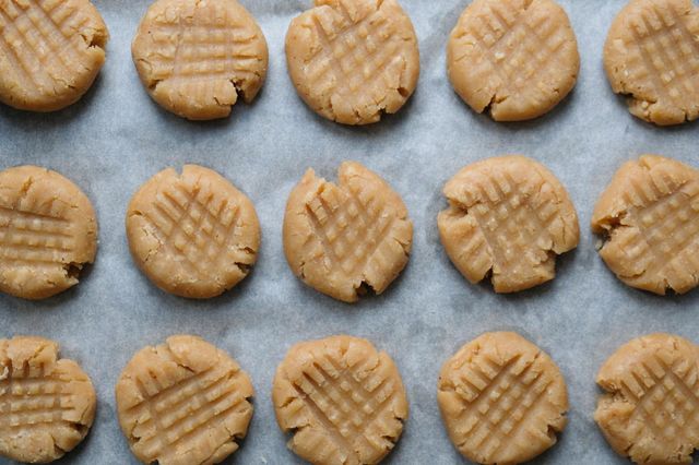 Flat lay with raw American peanut butter cookies on a baking sheet lined with baking paper