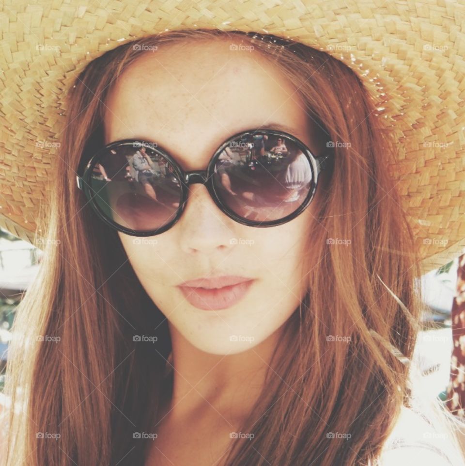 Close-up of a woman wearing hat with sunglasses