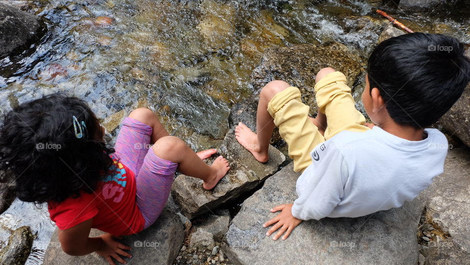 Kids sitting near a stream