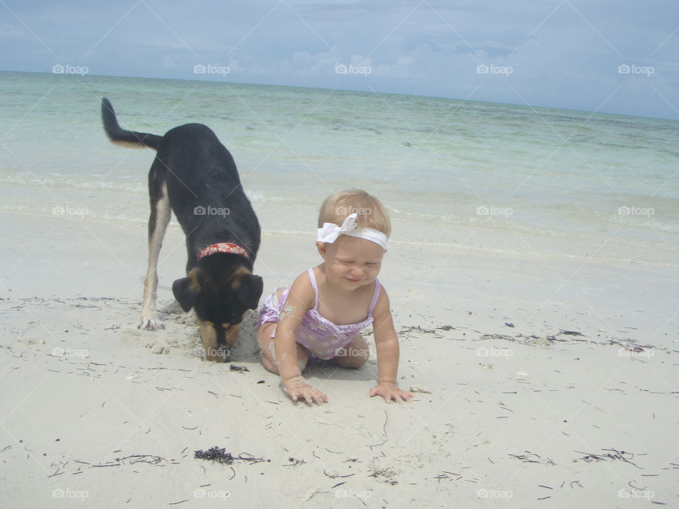 Baby playing with her pet dog