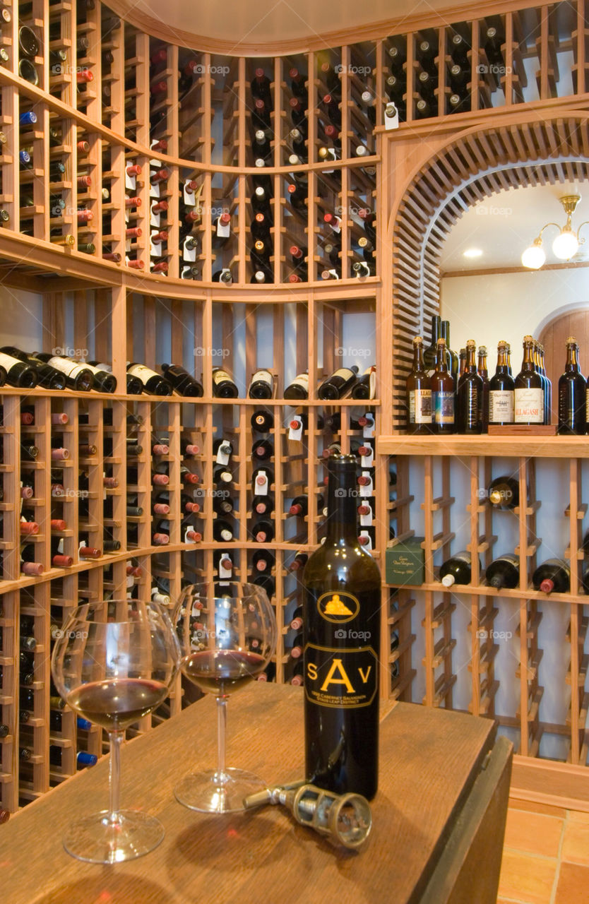 Bottle of wine and wine glasses in the wine cellar