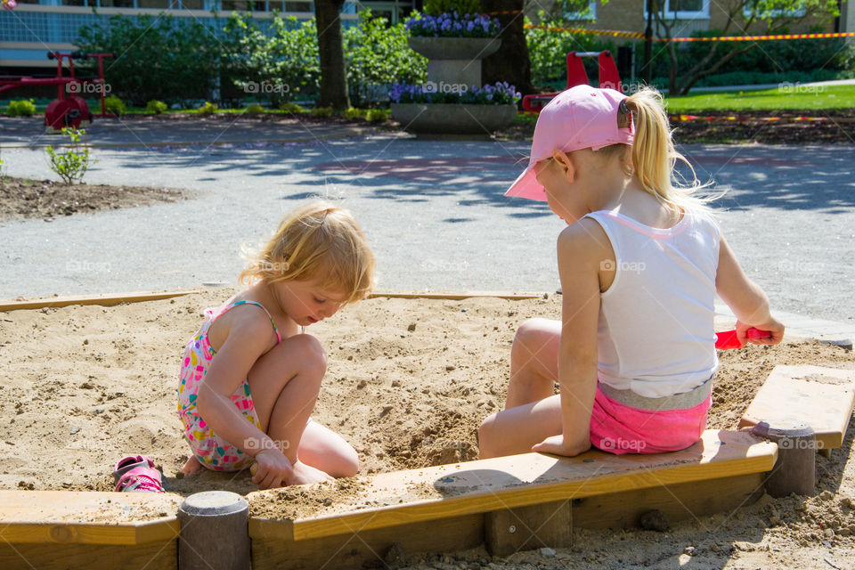 Young sister are olaying at a playground in Malmö Sweden.