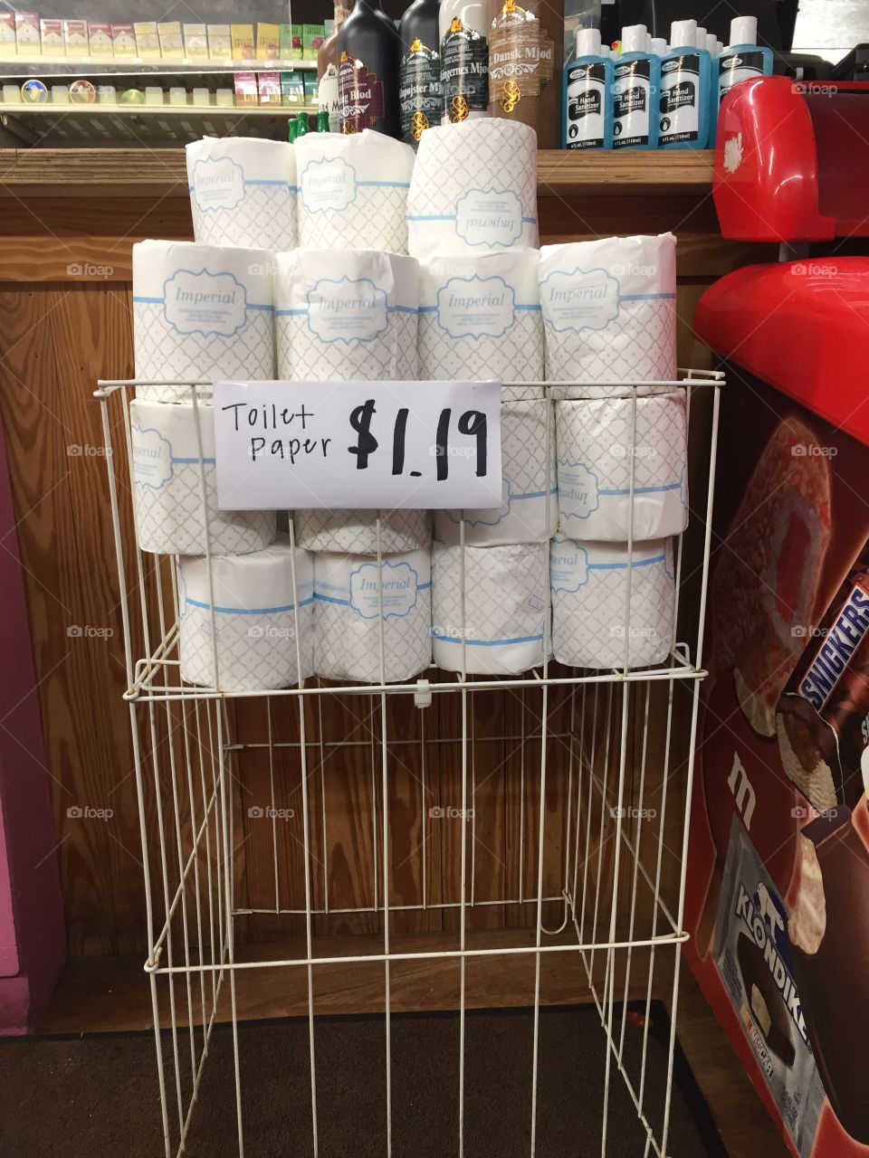 Rack of toilet paper for sale with hand sanitizer in background on counter.  Both hot commodities during the pandemic!