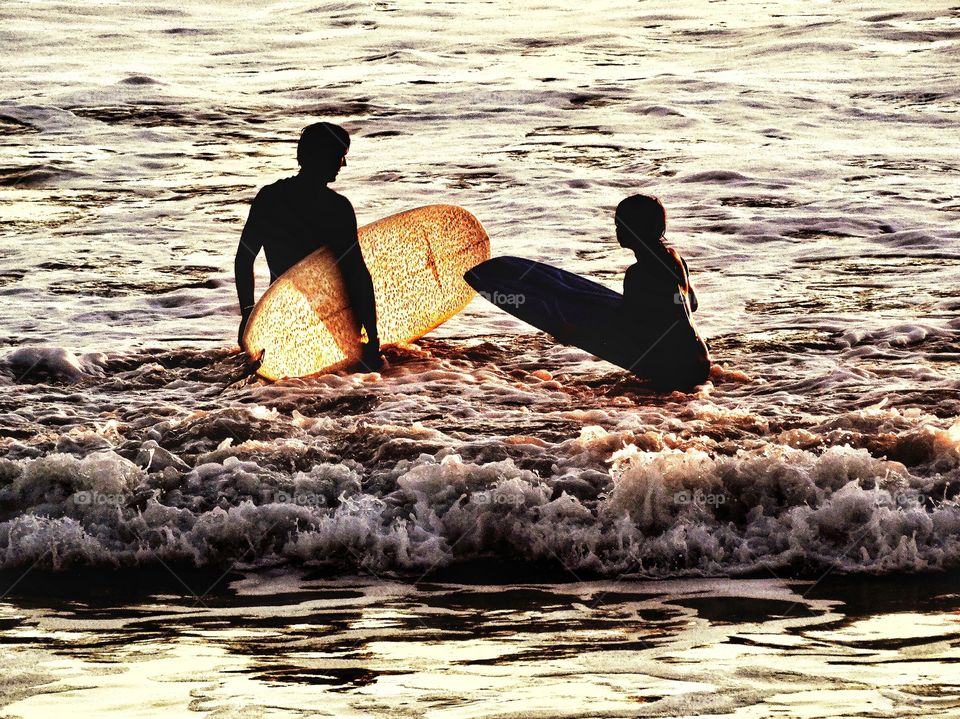 Father and son entering the waves in Half Moon Bay, California
