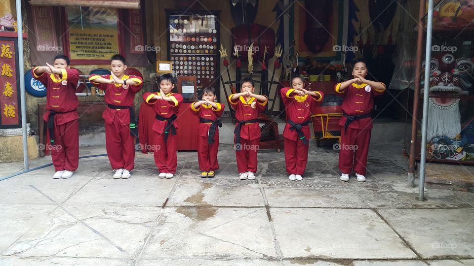 kids at kung fu school. young boys learning martial arts doing salute to  master