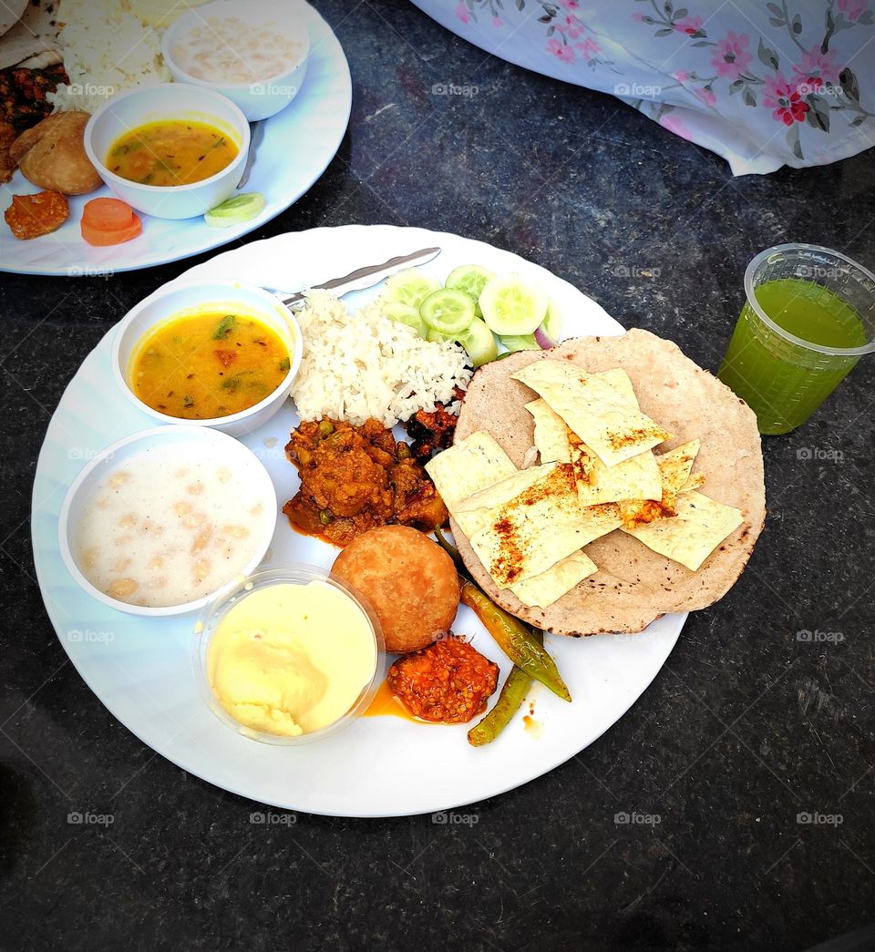 indian thali fully loaded with crisps and delicious items
