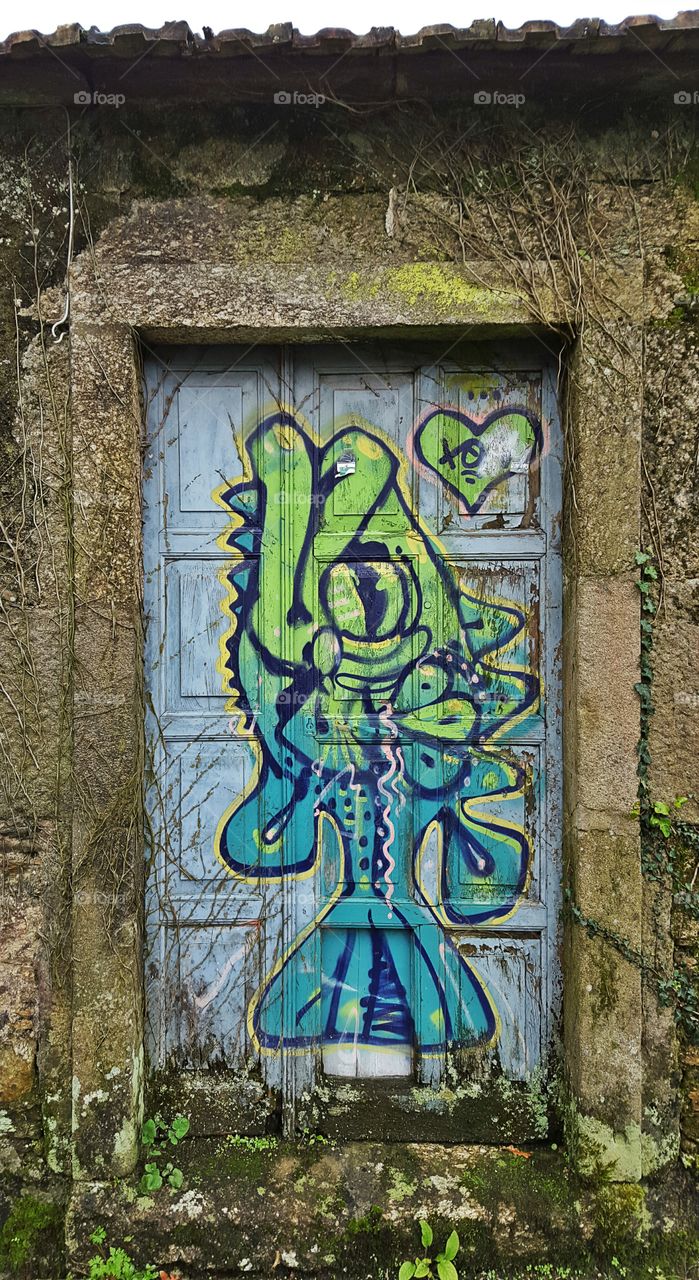 Graffiti on the door of an old abandoned house.