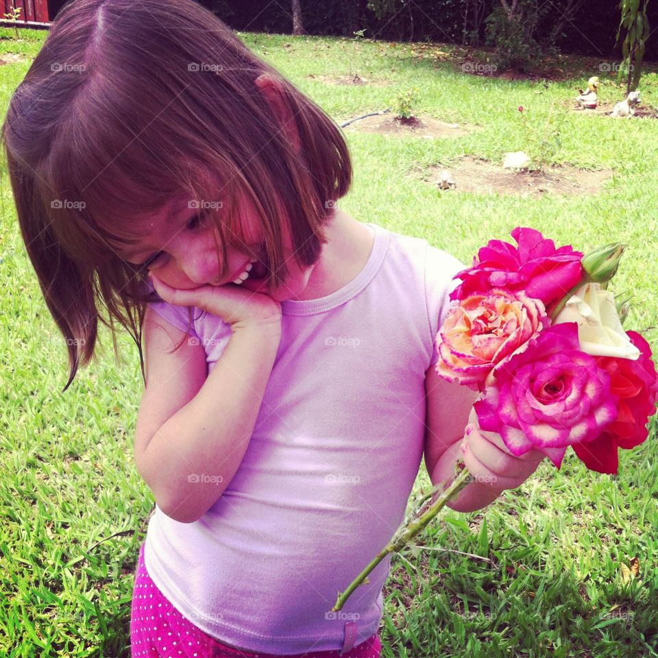 Meu sorriso encantador: a filhota com as flores do jardim. Buquê e alegria em união. 