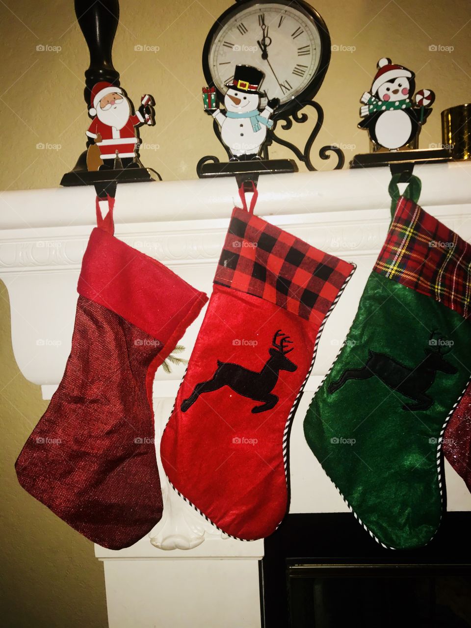 Beautiful red, green and plaid Christmas stockings hung by the chimney awaiting a visit from Santa. USA, America 
