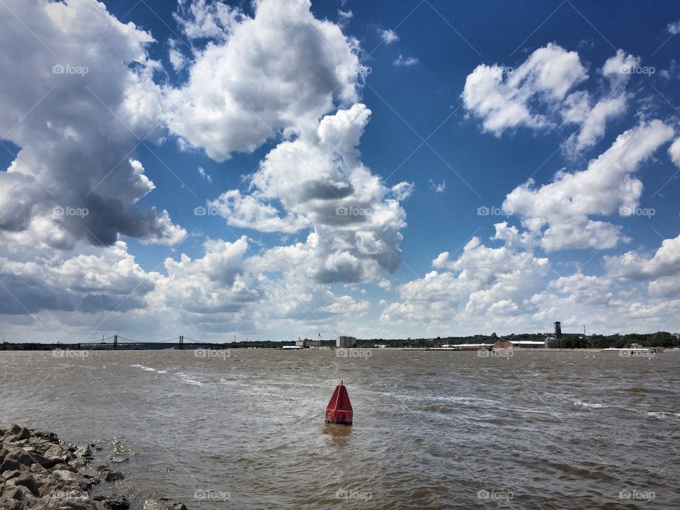 What does it mean when you see countless cumulonimbus clouds roll in? It usually means that a storm is brewing. When these clouds meet, they collide and tower. This photograph was taken at the Mississippi River on the Illinois side, with the Iowa border showing across. 