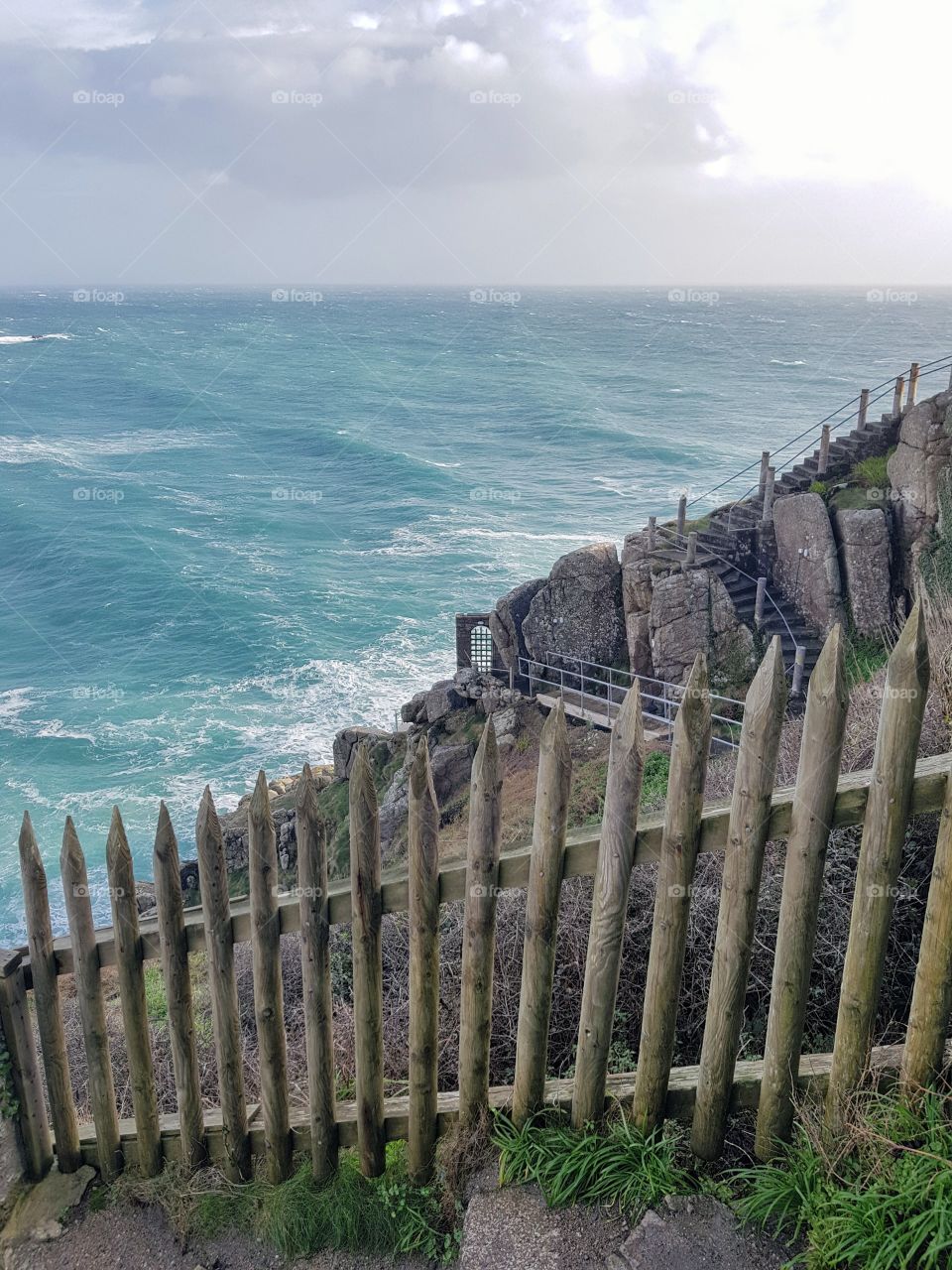 One small wooden fence separates brave site seers from the steep cliff overlooking the stormy sea.