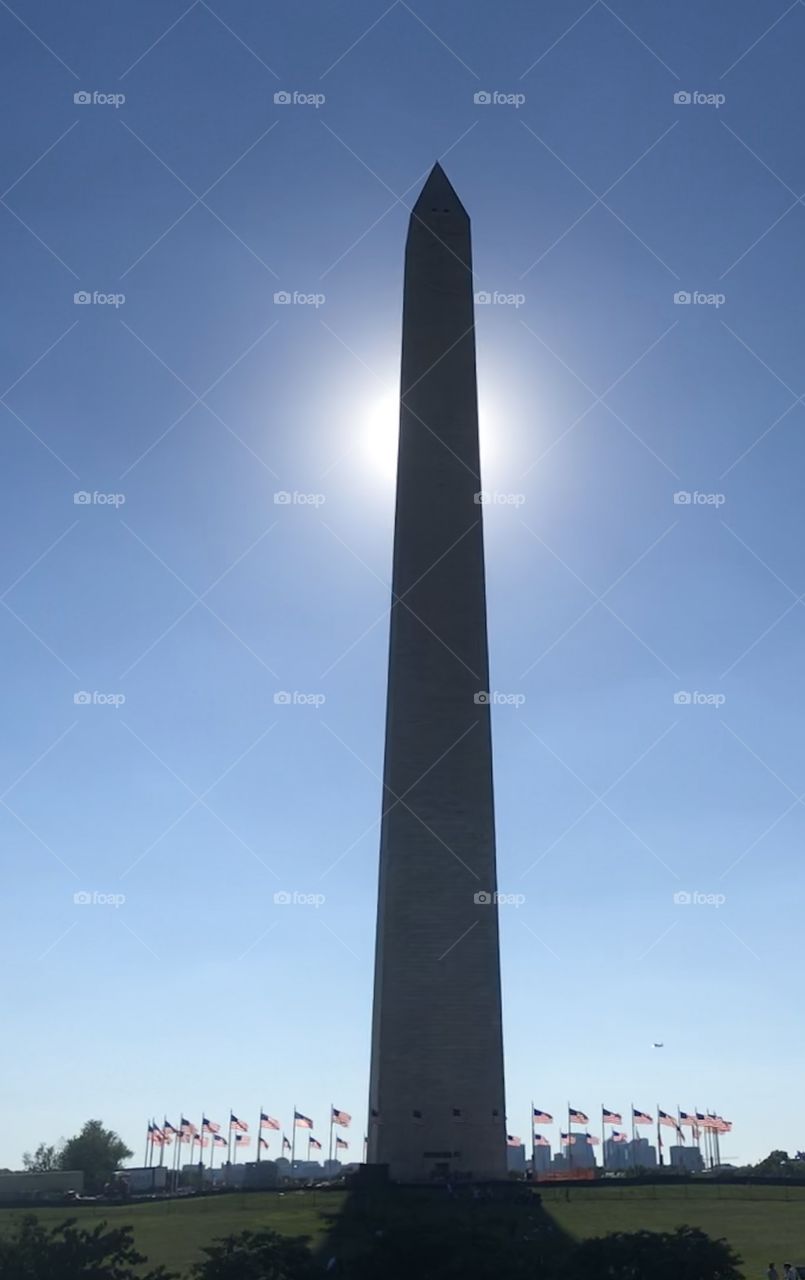 Sun behind Washington Monument in D. C. on a crystal clear sunny day in summer. 