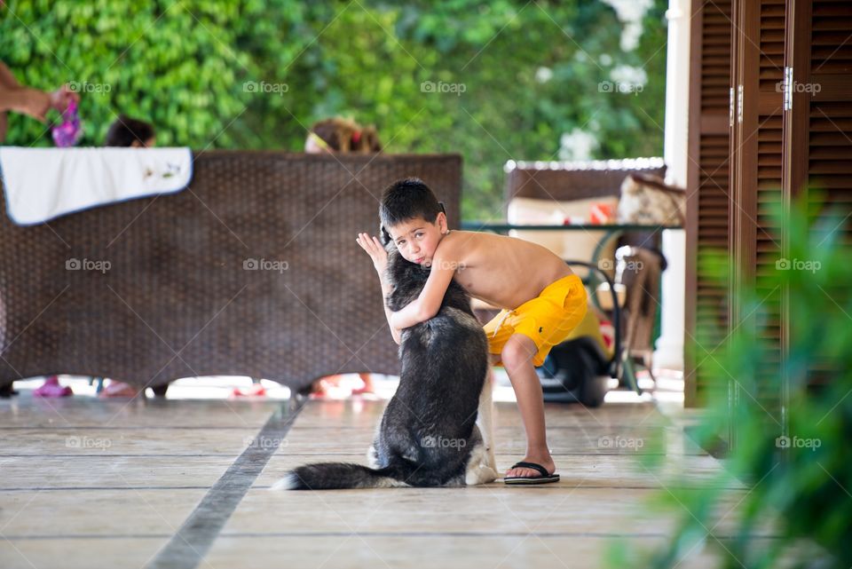 a boy hugging his dog in a funny way