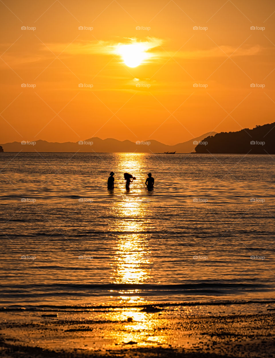 Silhouette of local people walk in the sea