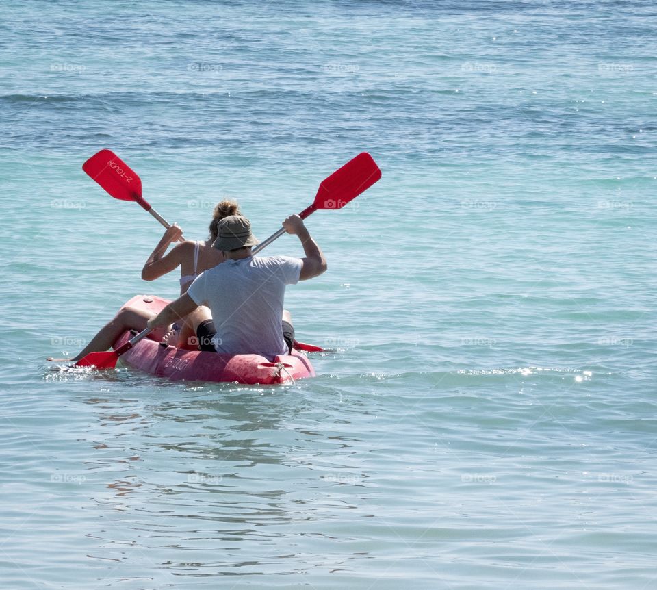 Lovers are sailing Kayak in the blue sea 