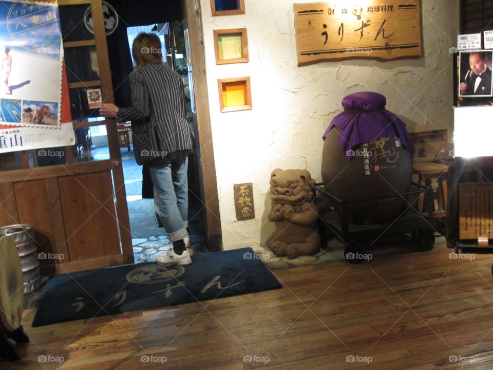 Fashionable Man Entering a Traditional Okinawan Restaurant in Tokyo Station, Japan.