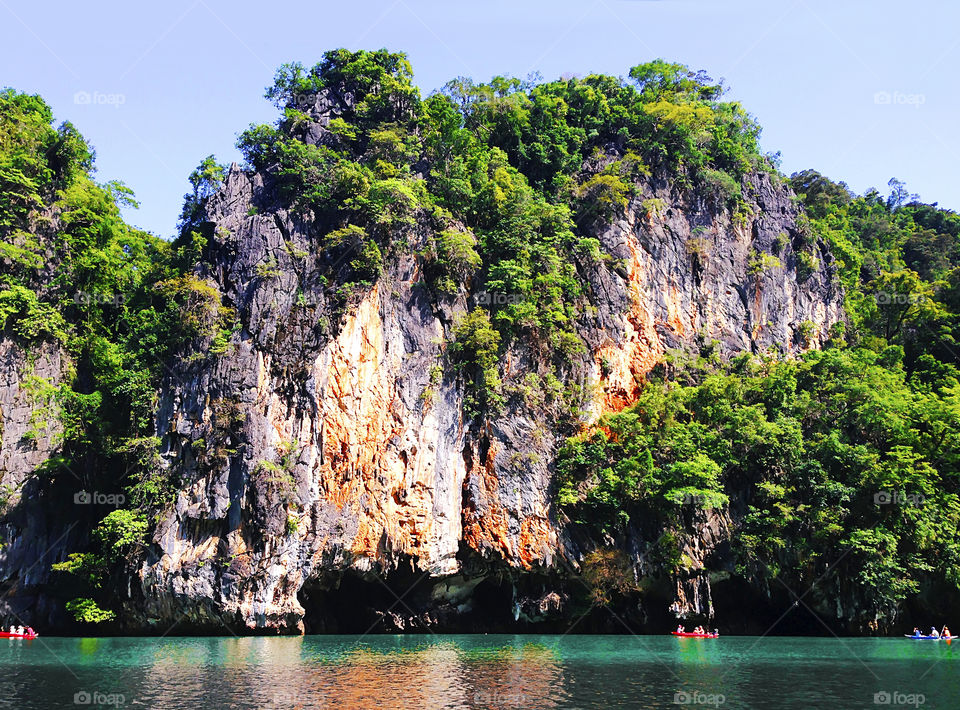 People swimming in boats under the Rocky landscape at the sea in Thailand 