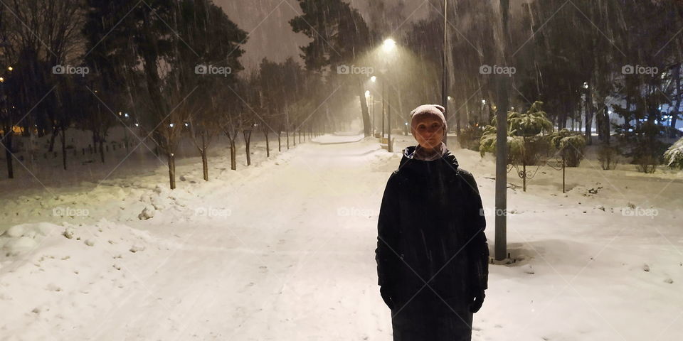 one girl in an empty park on a winter evening in the city of Kiev