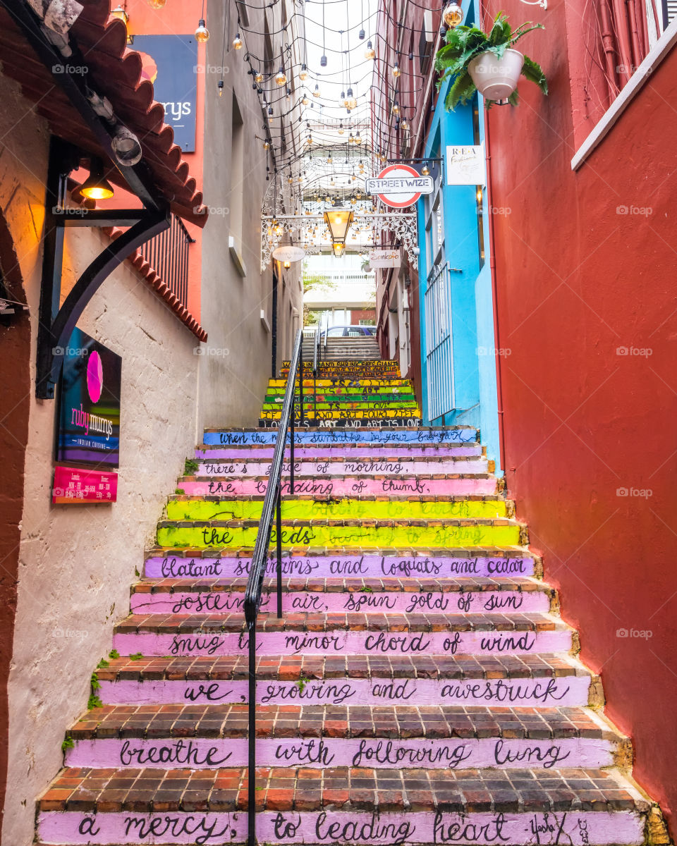 Brightly colored artistic stairs going up a narrow alley surrounded by colorful buildings. Hamilton Bermuda