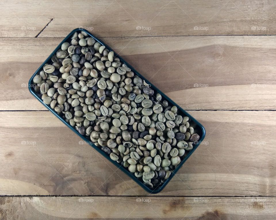 raw coffee beans on wooden background