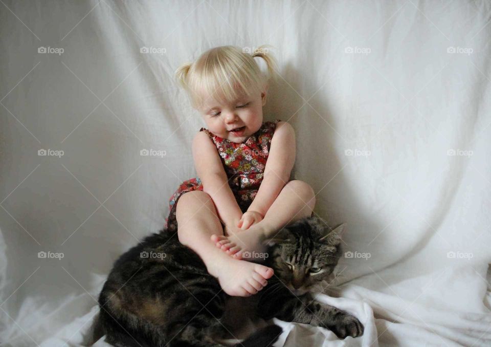 toddler girl and her tabby cat