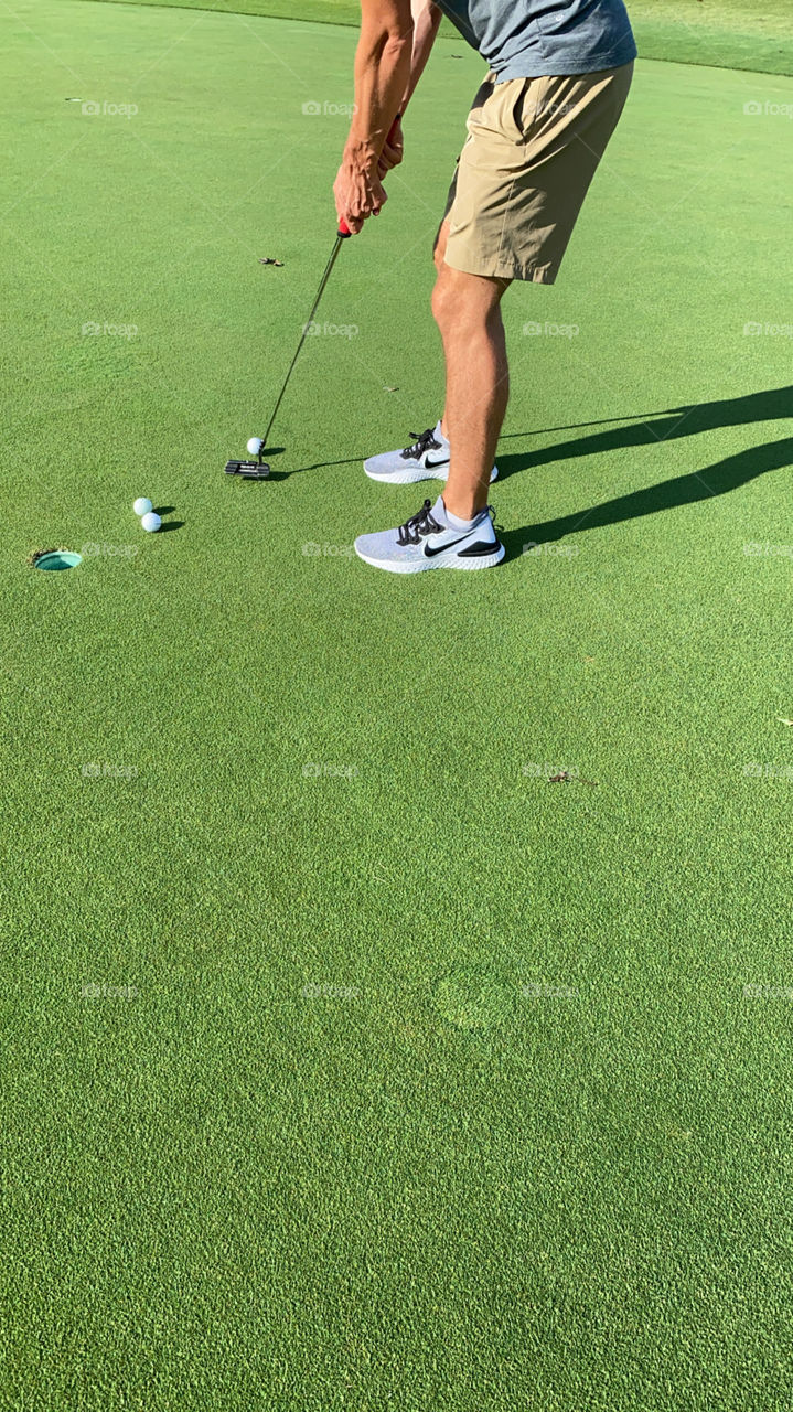 Man prepares to putt the ball.