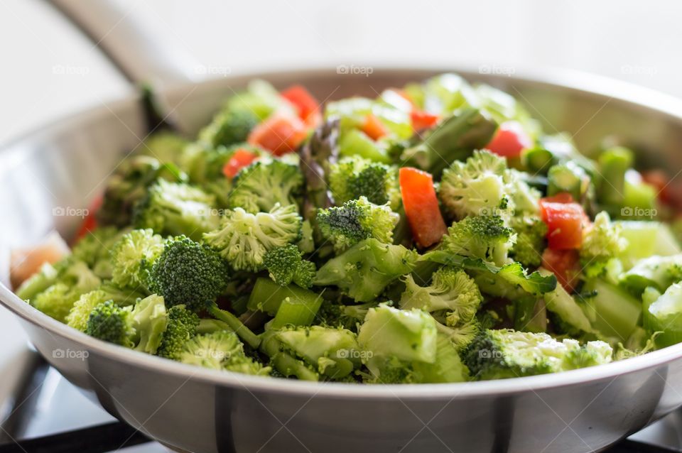 Fresh vegetables and chicken on a pan in the stove ready to stir fry.
