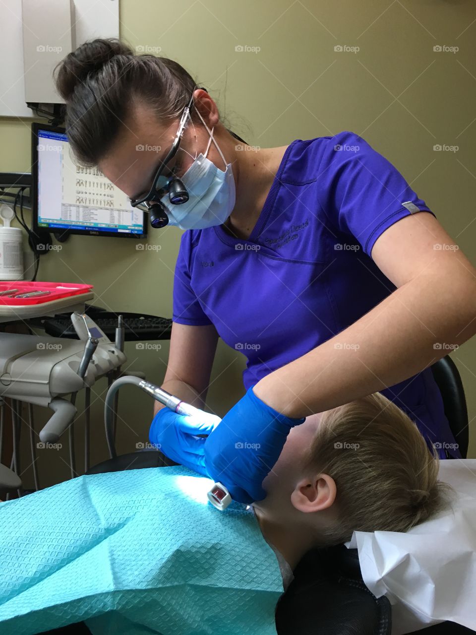 Female dentist examining boy wearing eyeglasses