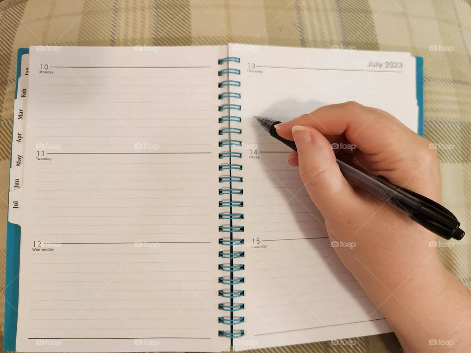 keeping track of your days, thoughts, and schedules by writing in a day planner book