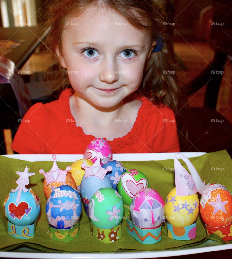 Young girl presents her colourful Easter eggs 