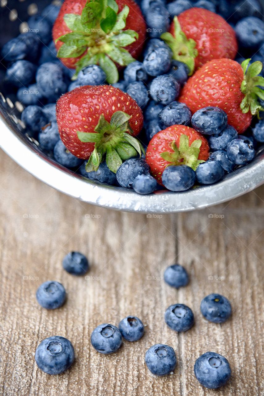 Container of a berries on wooden table