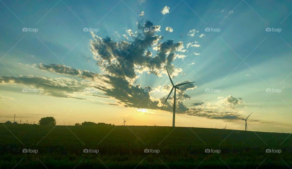 The essence of the Midwest (Iowa). An aesthetic sunset behind the clouds with a wind turbine in the front