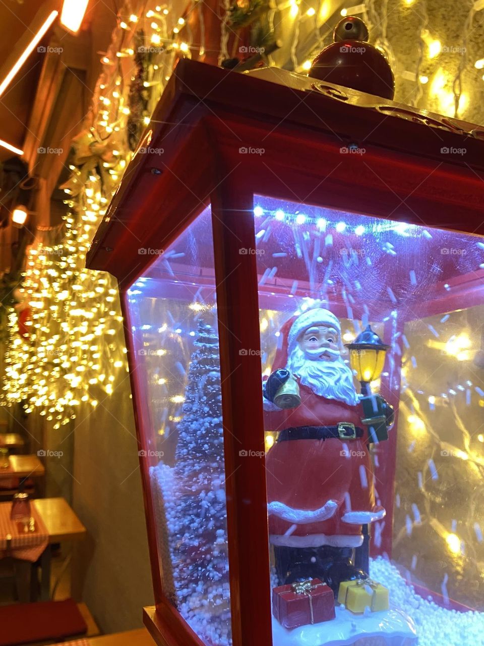 Santa Claus in a holiday lamp bringing Christmas joy with twinkling lights in the background.