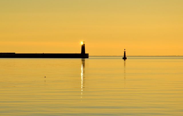 Sun reflecting in lighthouse during sunrise in Gdynia 