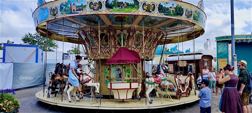 An old fashioned carousel is among the rides of the “Gäubodenvolksfest”, a people’s festival held every year in late August in “Straubing”, “Bavaria”. Its hand painted horses and figurines are beautiful iconic novelties. 2024. Hypnotic Productions