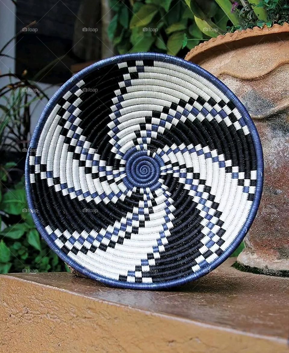 The image shows a group of hand -made dishes of wicker, decorated with colored embroideries with beautiful floral shapes, and is elegantly displayed in a warm corner that combines heritage and beauty, which gives the place an artistic spirit and attr