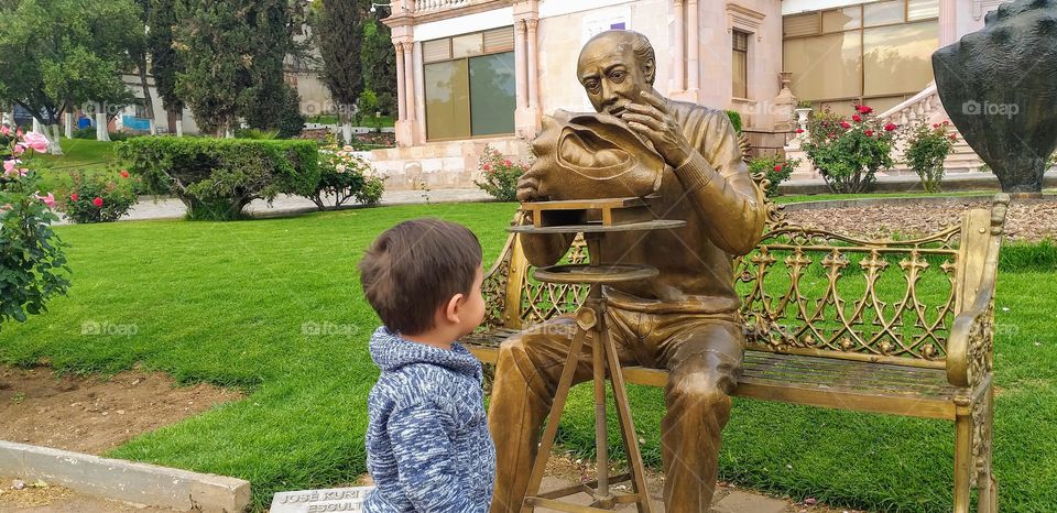 baby looking at statue