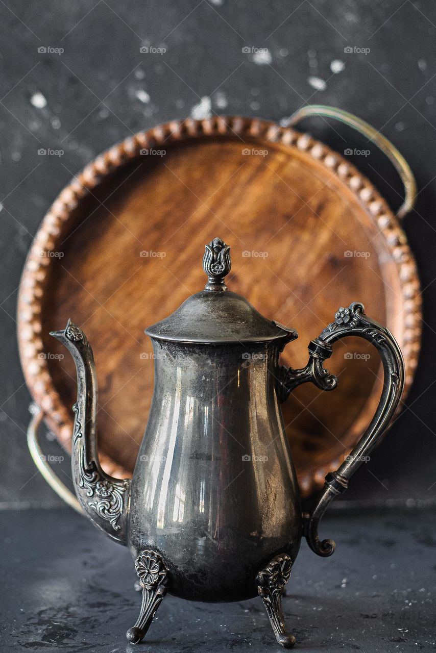 Antique metal jug with wooden tray.