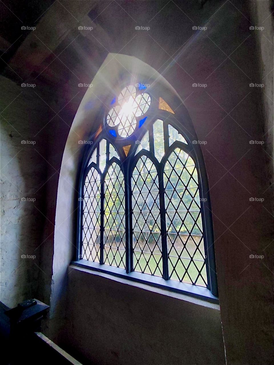 This is an antique stain glass window with multiple arches and a rosetta shape on top inside the medieval parish church of “Altenkirchen” on the island “Rügen” in the “Baltic Sea” or “Ostsee”in “Western Pomerania”, Germany. 2024. Hypnotic Productions