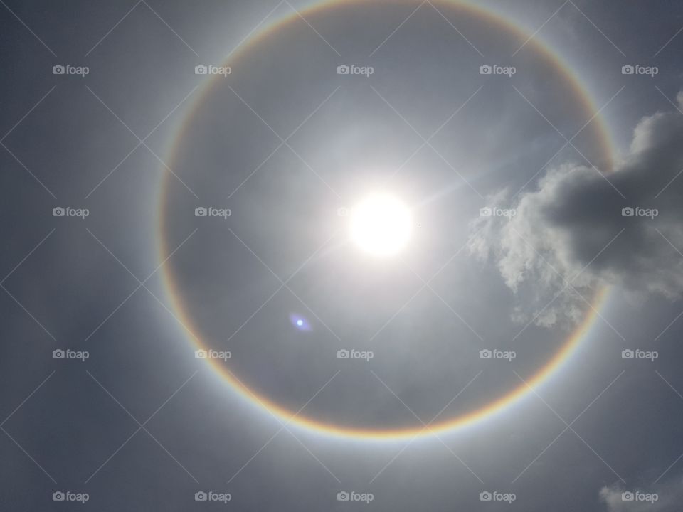 circle rainbow aura full spectrum around the sun in the sky